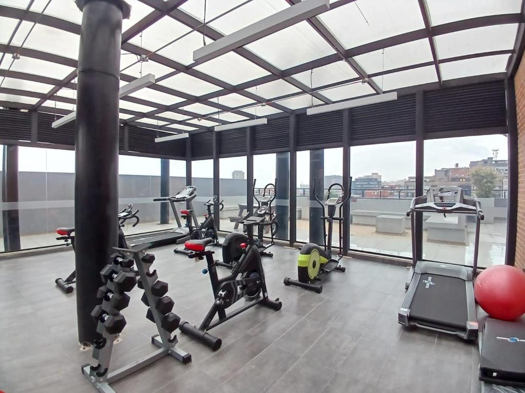 un gimnasio con equipo cardiovascular en una gran sala con ventanas en Moderno apartamento 211 en Bogotá