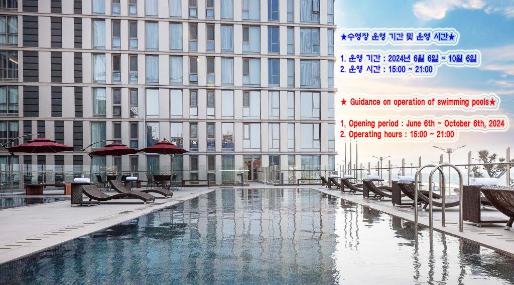 a large building with a swimming pool in front of a building at Hotel Regent Marine The Blue in Jeju