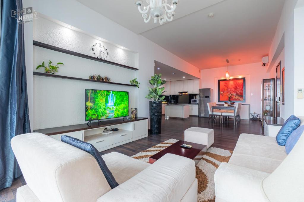 a living room with white furniture and a flat screen tv at Son&Henry Sailing Tower in Ho Chi Minh City