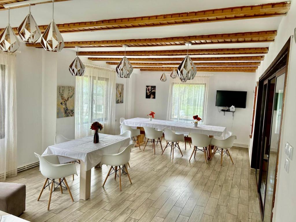 a white dining room with white tables and chairs at Vila Monica in Bran