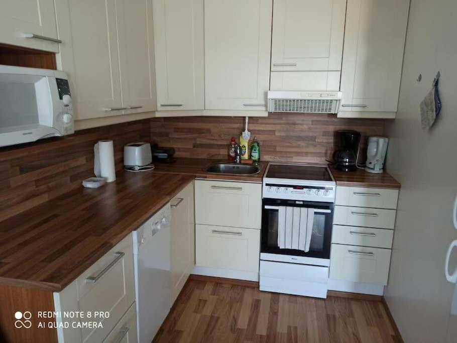 a kitchen with white cabinets and a stove top oven at New home in the citycenter. in Rovaniemi
