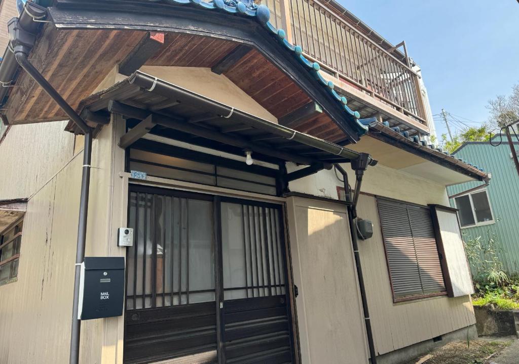 逗子的住宿－JapaneseTraditional house【Zushi Kotsubo ONDa】，一座带门和阳台的建筑
