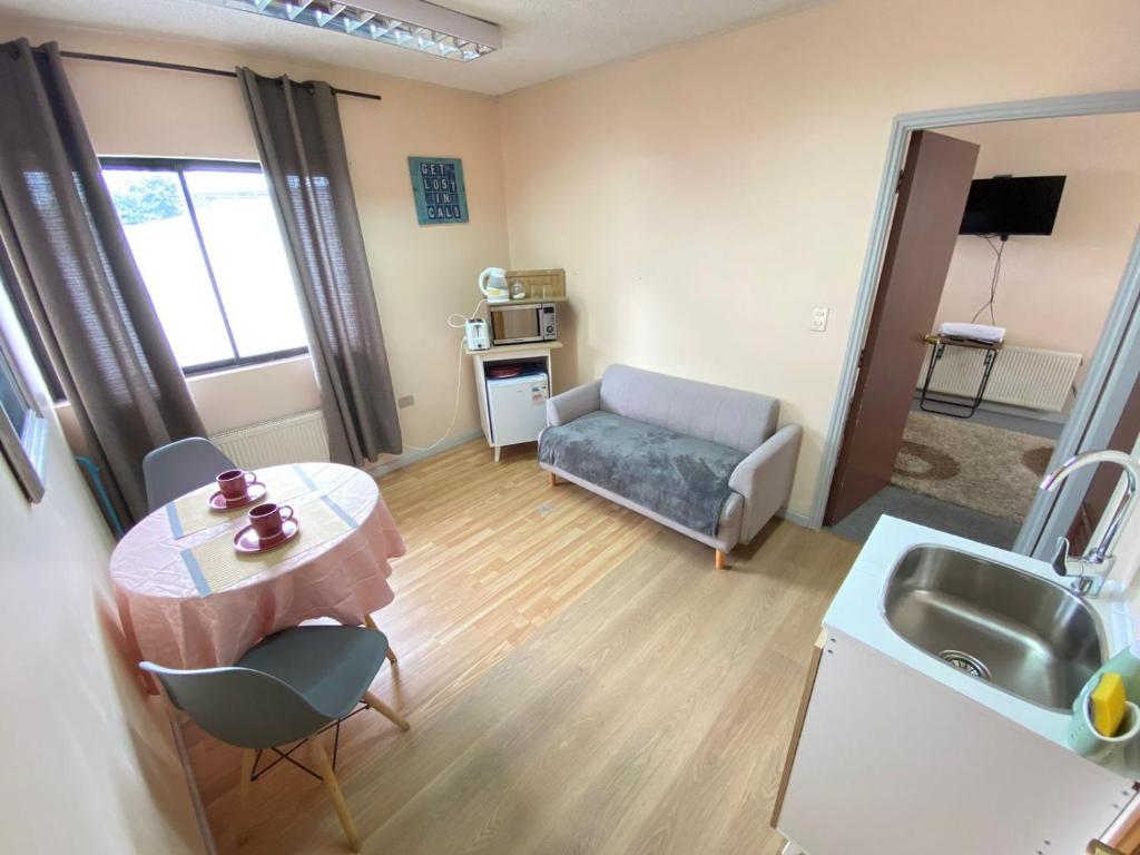 uma pequena sala de estar com uma mesa e um sofá em Matta Central em Osorno