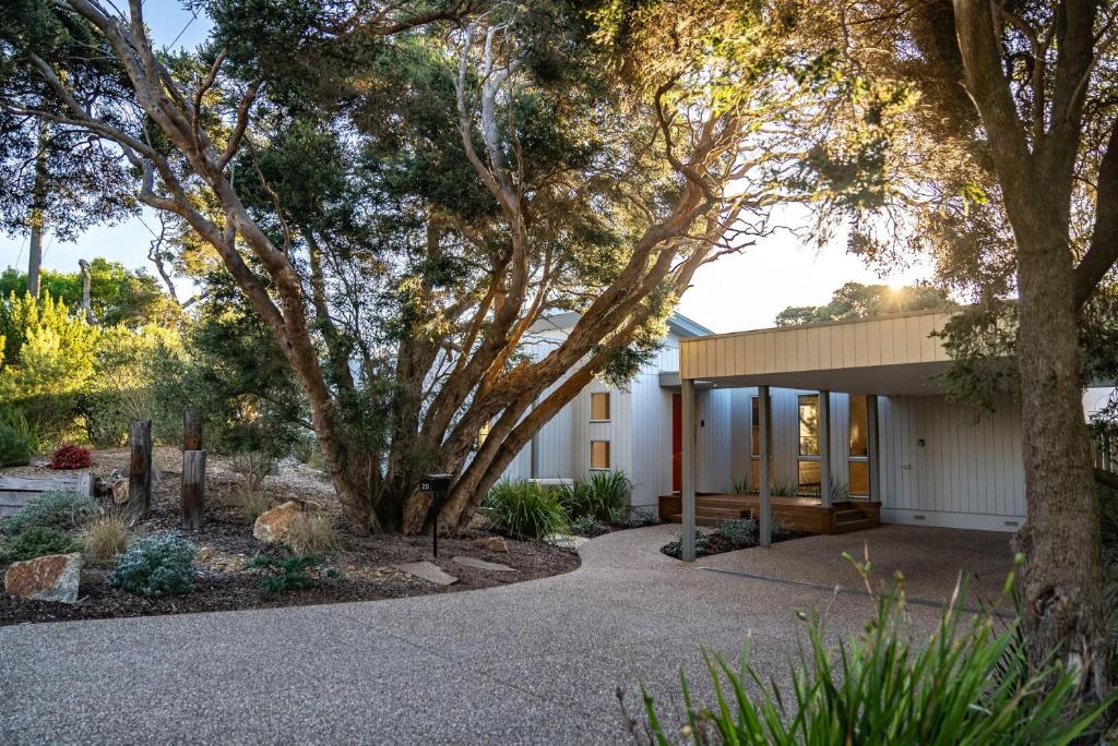 a home with a gravel driveway and trees at You Me And The Sea Blairgowrie in Blairgowrie