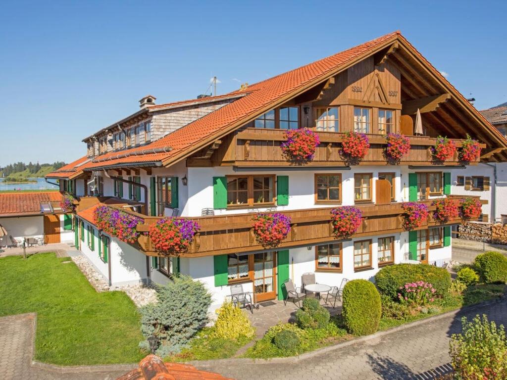Una casa grande con flores al costado. en Nice holiday home near ski-lift, en Schwangau