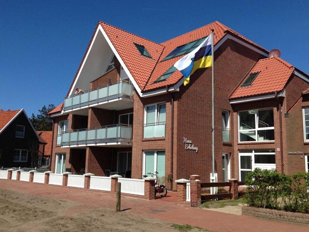 尤伊斯特的住宿－Lütje Sandbank Modern retreat，砖楼前悬挂的旗帜