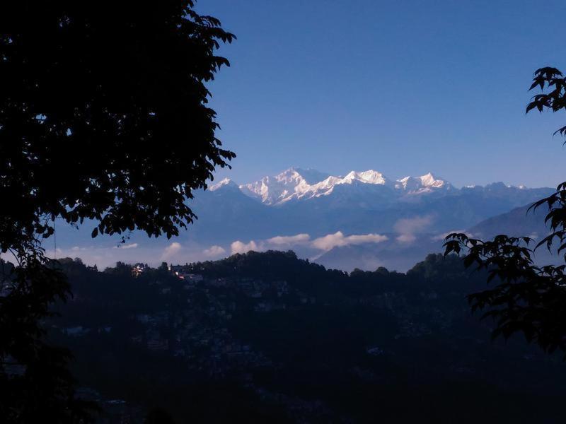 a view of a mountain range with snow capped mountains at Travellers' Den in Darjeeling