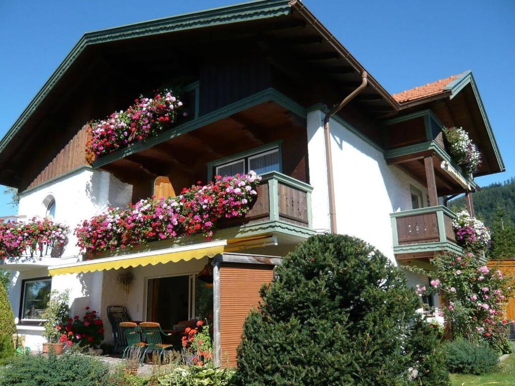 una casa con cajas de flores a un lado. en Lovely holiday home near ski-lift en Inzell