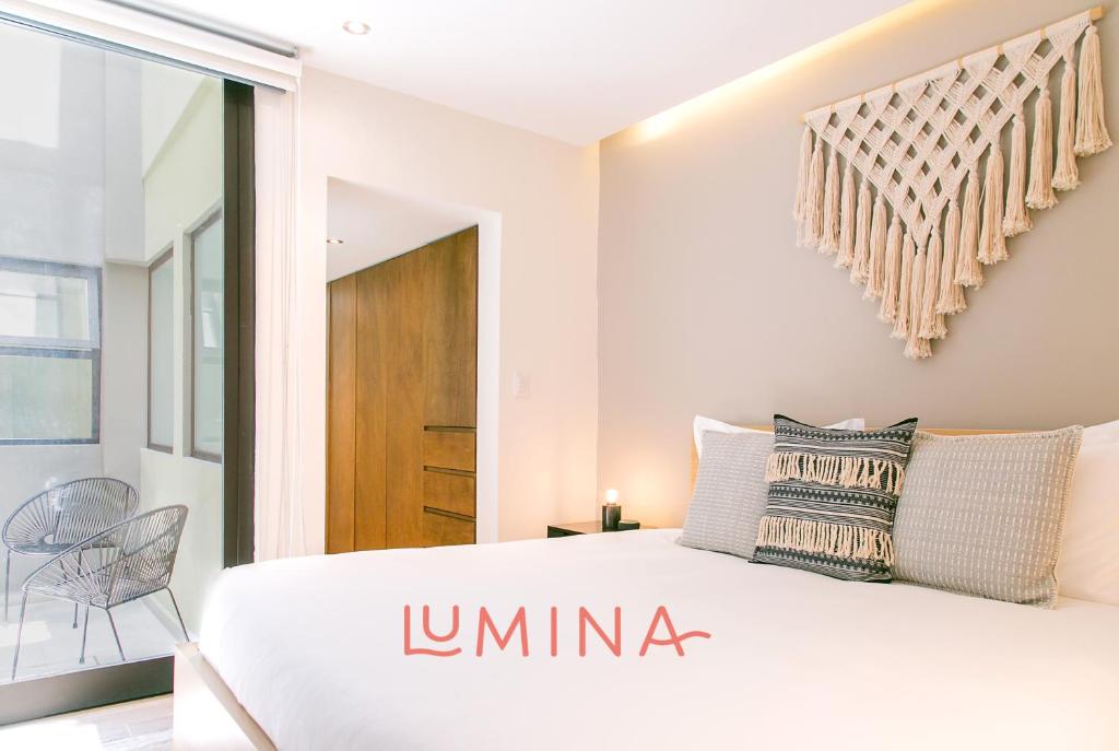 Lumina at Noma Condesa Mexico City في مدينة ميكسيكو: غرفة نوم بسرير ابيض كبير ونافذة