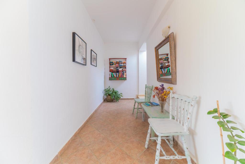 a hallway with chairs and a table and a mirror at Kassiani Studios in Plakias