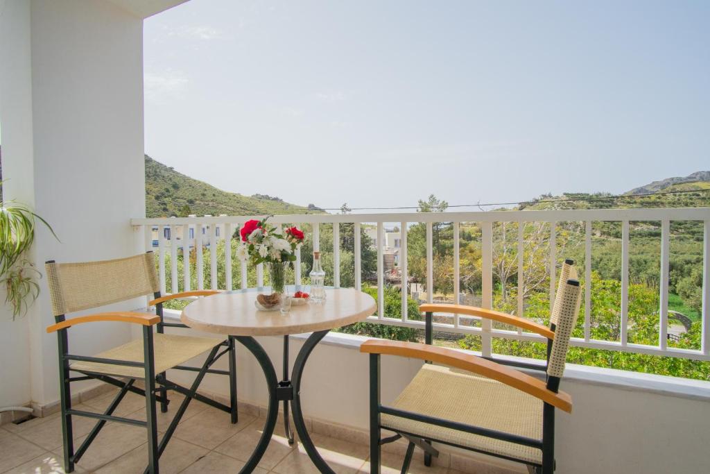 a table and chairs on a balcony with a view at Kassiani Studios in Plakias