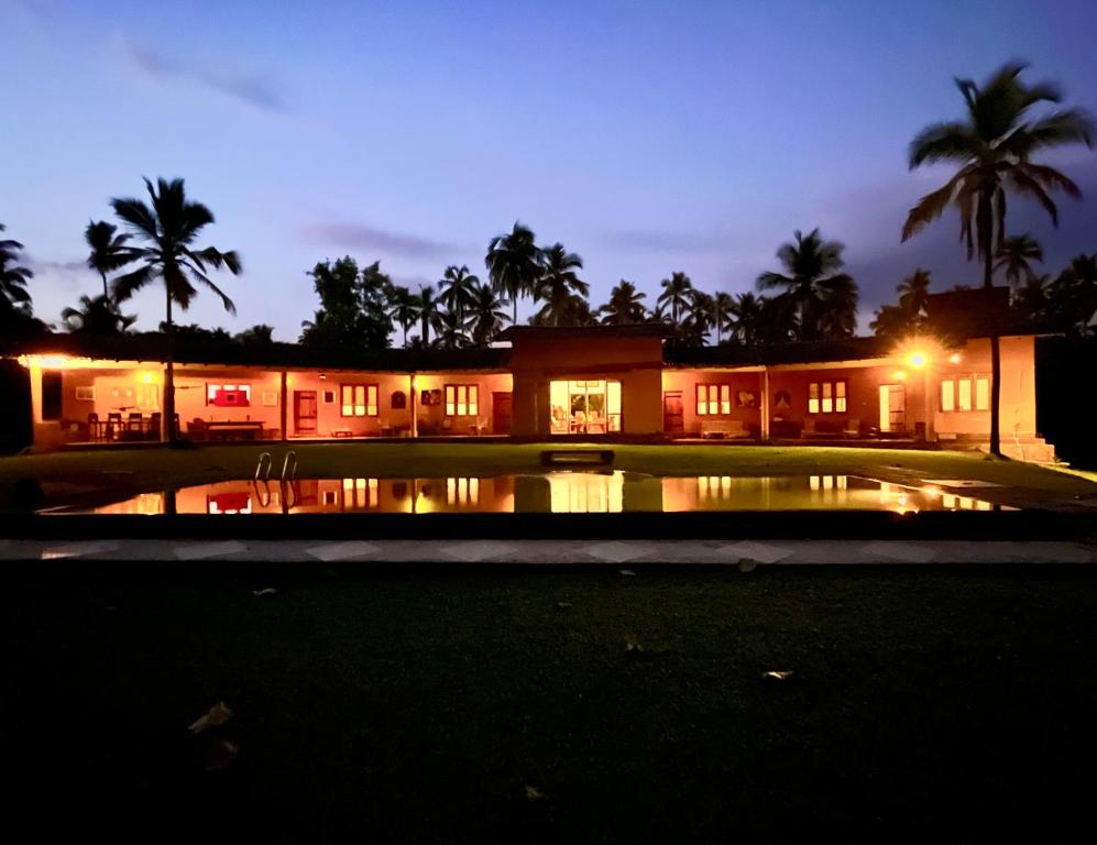 a building with a pool in front of it at night at Rivendell Twisted Tree in Kurunegala