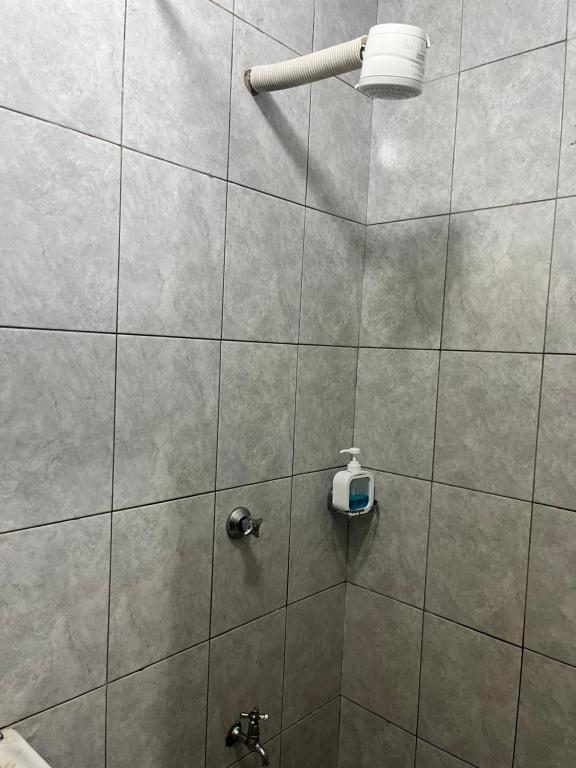 a tiled shower with a soap dispenser on the wall at JoJo Jovial Homes in Kiambu