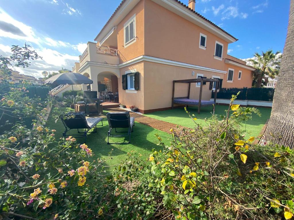 a house with a yard with chairs and a playground at Can Guerrero pet friendly a 500 metros de la playa! in Calas de Mallorca