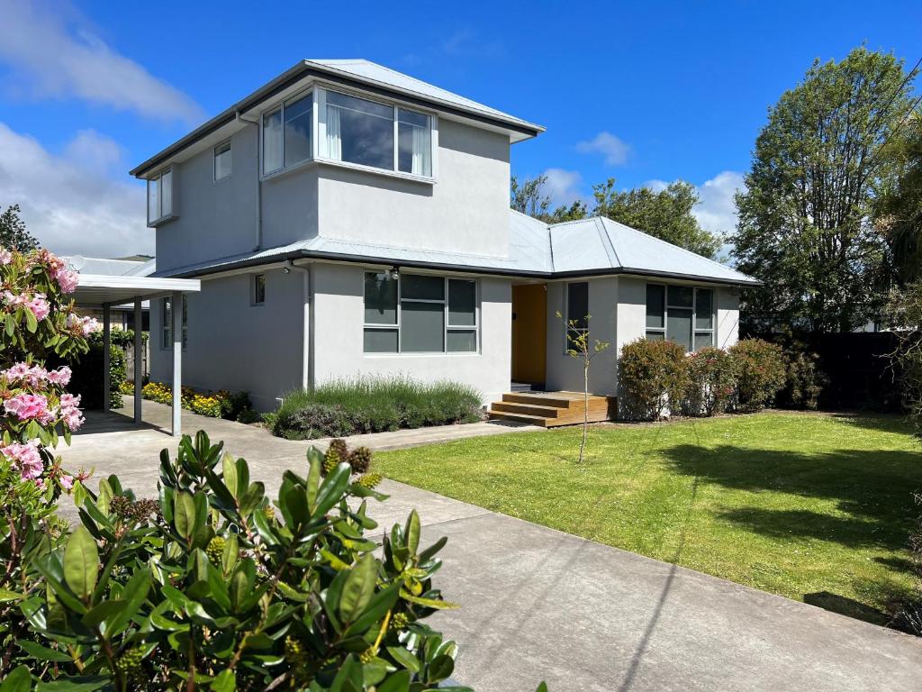 een groot wit huis met een tuin bij Charlesworth Villa - Christchurch Holiday Homes in Christchurch