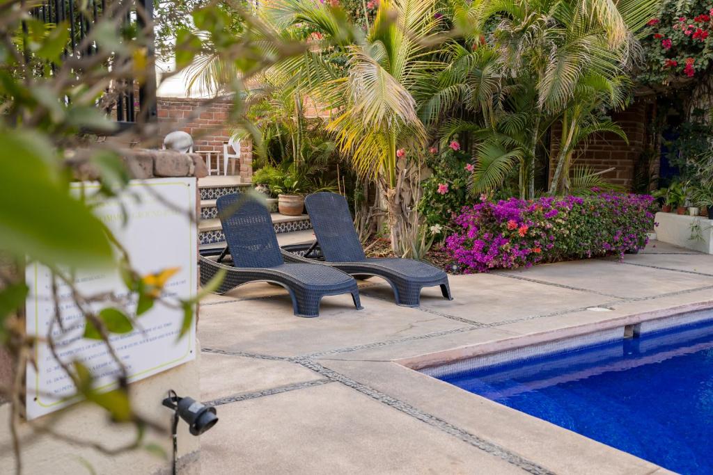 two blue chairs sitting next to a swimming pool at Cabo's Hidden Gem! Steps to the Marina or Beach in Cabo San Lucas
