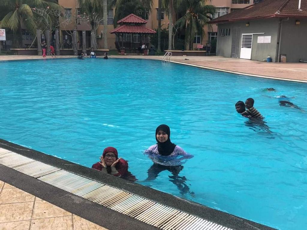 a group of children swimming in a swimming pool at budget Homestay and selesa with big swimming pool in Mantin