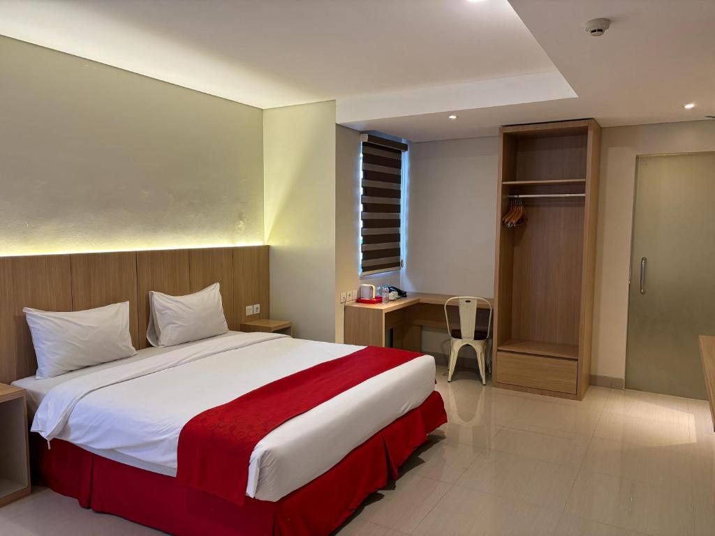 a bedroom with a large bed with a red blanket at Hotel Brothers Inn Babarsari in Seturan