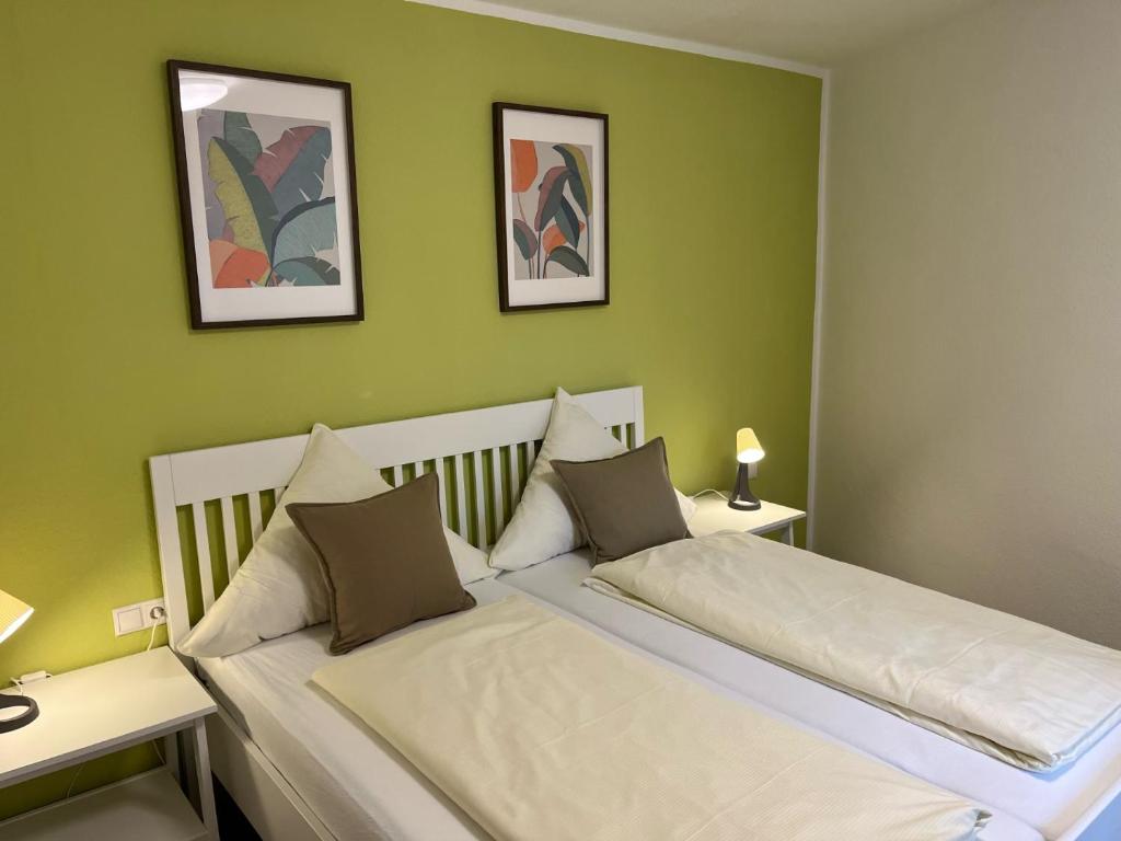 アンダーナッハにあるGasthaus Stammbaumの緑の壁のベッドルーム1室(ベッド2台付)