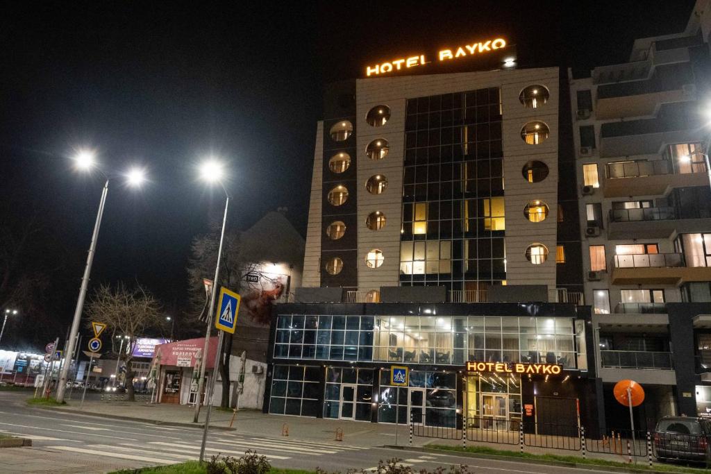 ein Hotel in der Nacht mit einem Gebäude und Straßenbeleuchtung in der Unterkunft HOTEL BAYKO in Plowdiw