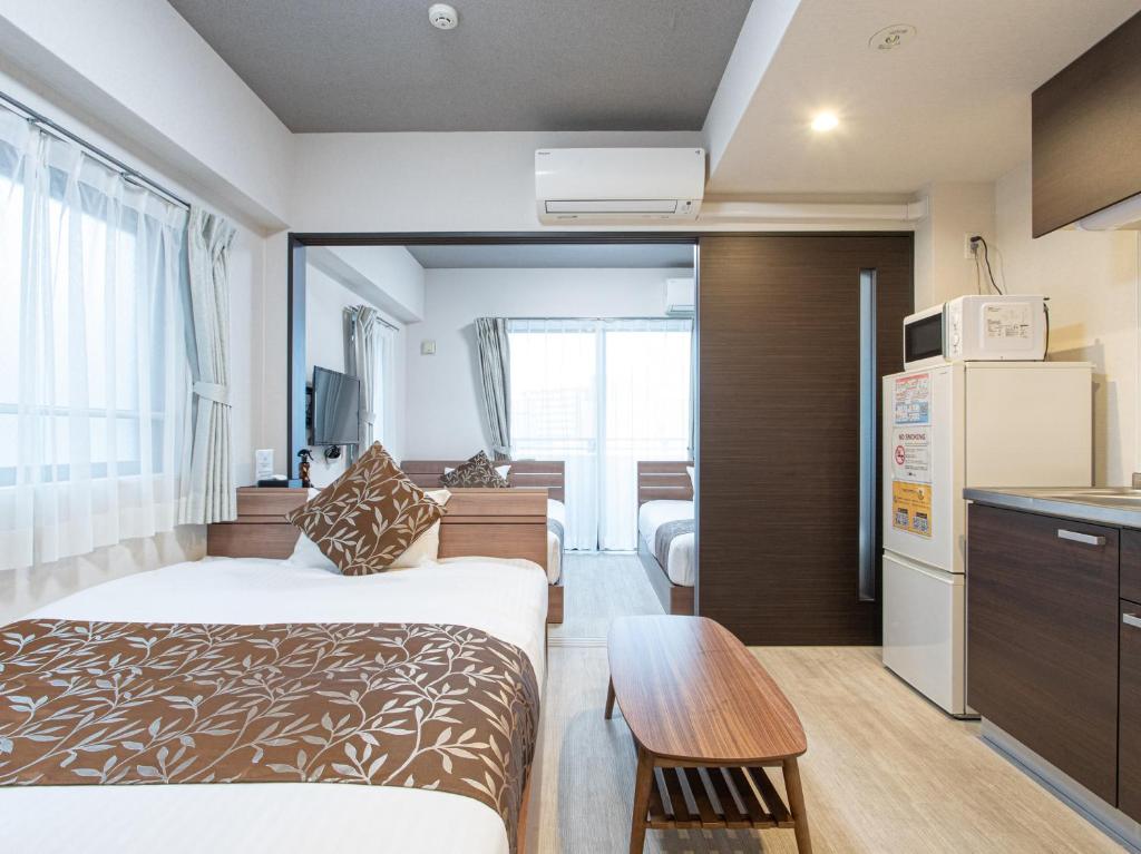 pokój hotelowy z łóżkiem i kuchnią w obiekcie Dream Inn Hakata w mieście Fukuoka