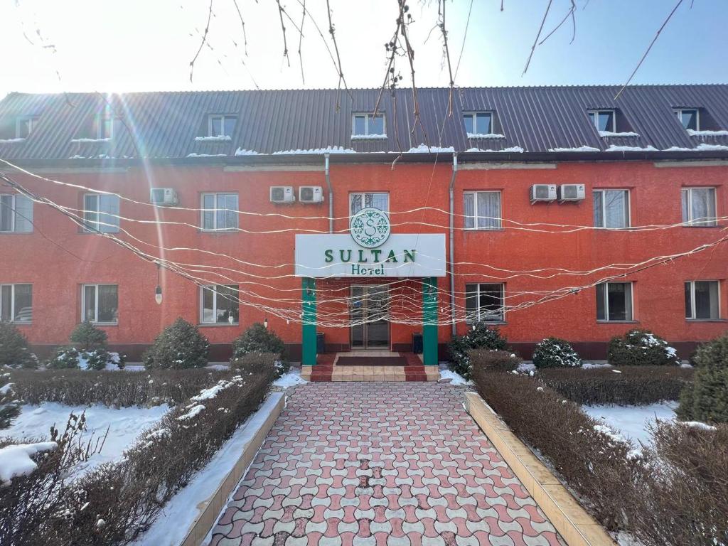 czerwony budynek z napisem "Sunan hotel" w obiekcie Sultan w mieście Biszkek