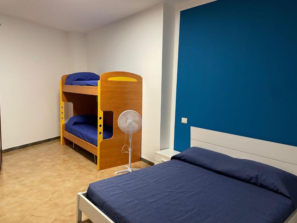 a bedroom with a bunk bed and a blue wall at Casa ALCA in Acquavella