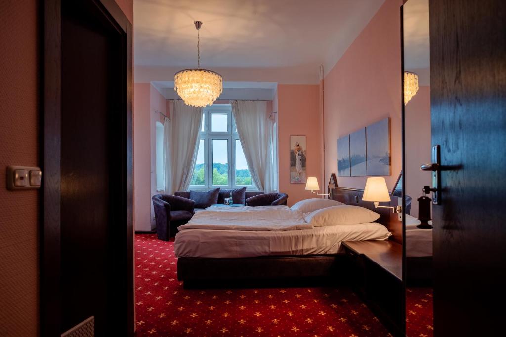 a bedroom with a bed and a living room at Hotel & Restaurant Bergschlösschen in Buckow