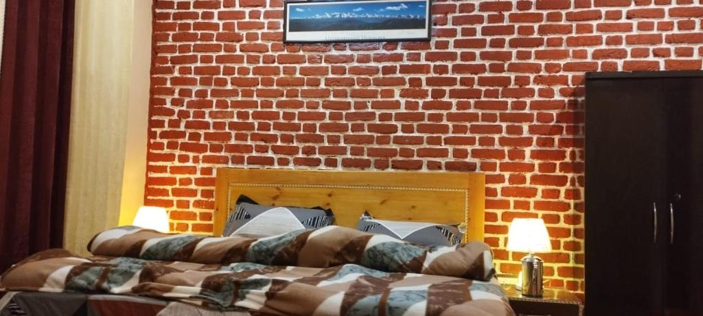 a brick wall with two beds in a room at Himalayan Heights Bara Devi in Nainital