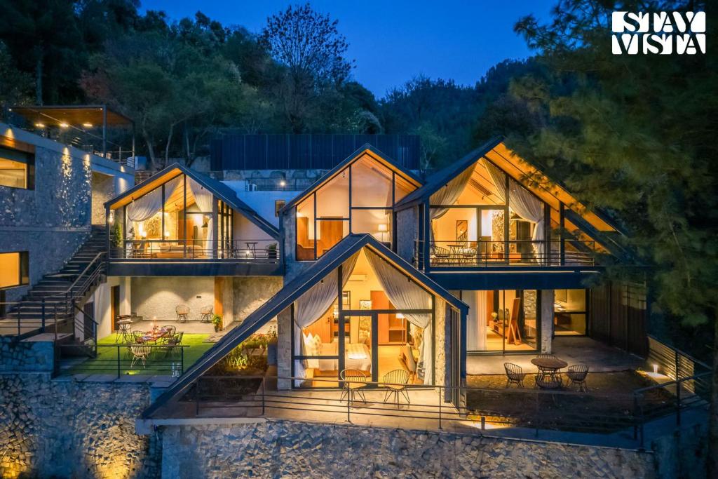 a house in the woods at night at StayVista at Shai Sher Estate with Bonfire, BBQ and Lawn in Shimla