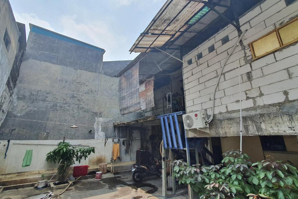 ein Gebäude mit einem Motorrad, das davor geparkt ist in der Unterkunft OYO 93895 Koh Wat Homestay Syariah in Plosobegem