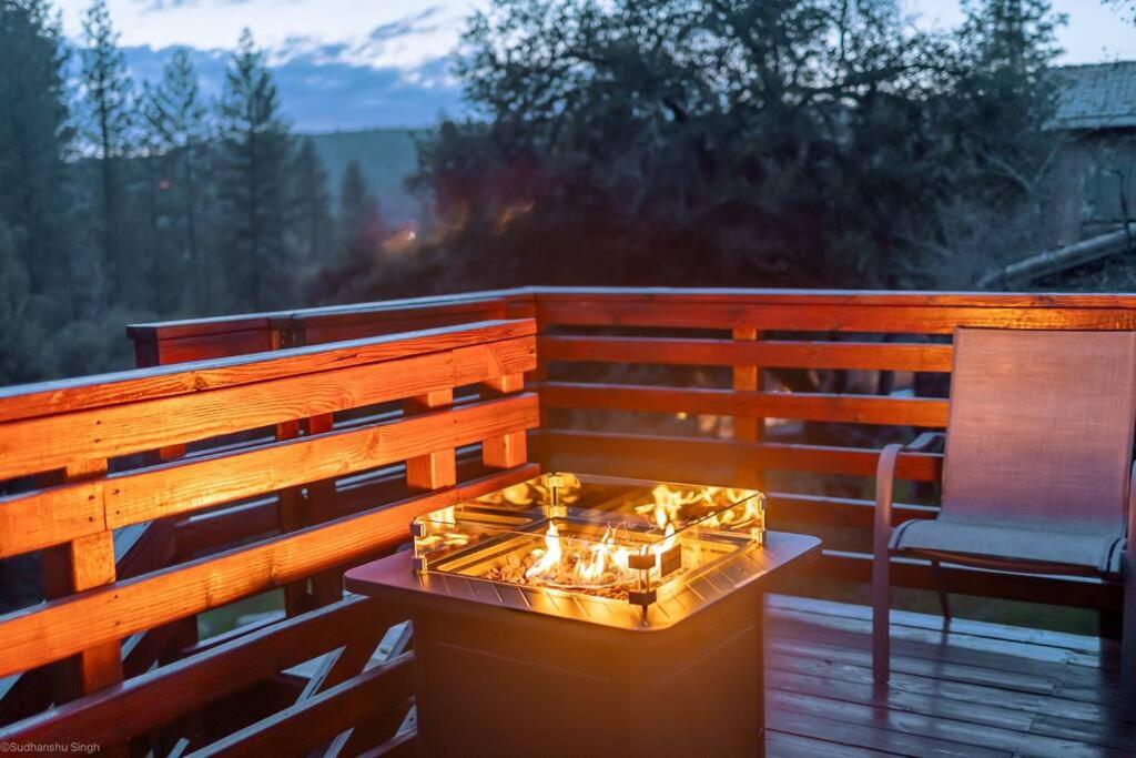 a glass table on a wooden deck with a chair at Mountain View, near Yosemite & Bass Lake, BBQ, Fireplace,EVC in Oakhurst