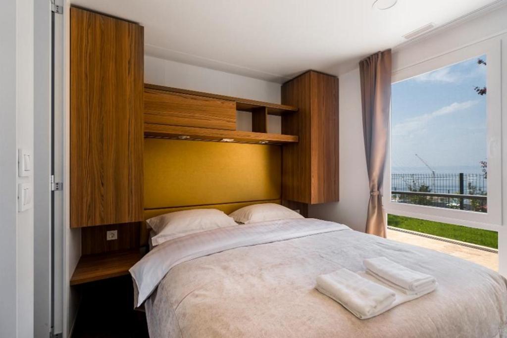 sypialnia z dużym łóżkiem z dwoma ręcznikami w obiekcie SUNNY Mobile Homes Bijela Uvala w Poreču