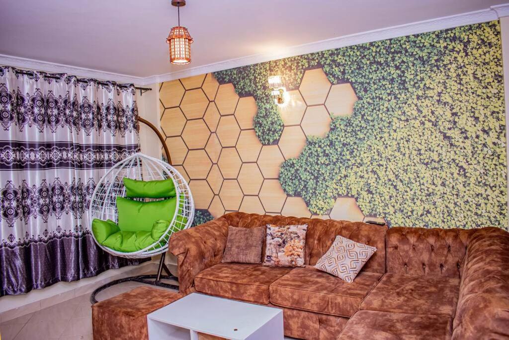 a living room with a couch and a wall mural at Dandy Home, 2 BdRm, Estn Bypass Kamakis Greenspot in Ruiru