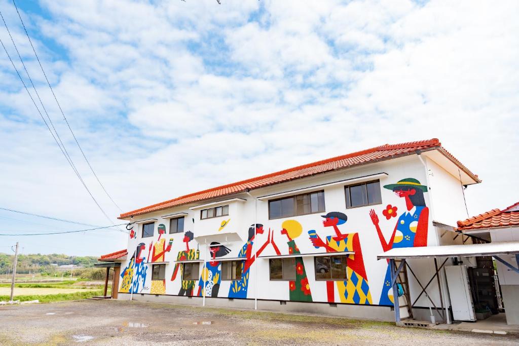 un edificio con una pintura a un lado. en ikibase Guest House, en Iki