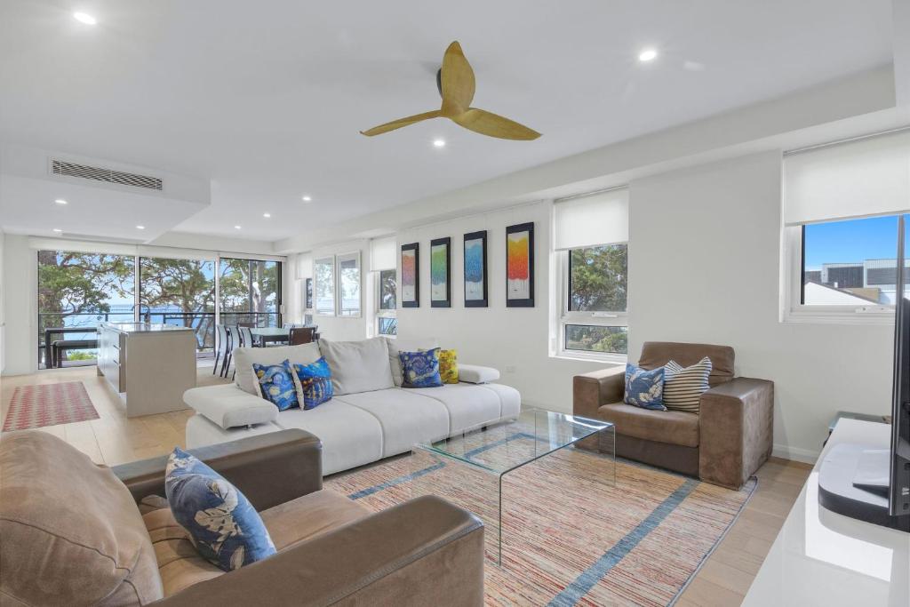a living room with a couch and chairs at The Beach Apartment in Huskisson