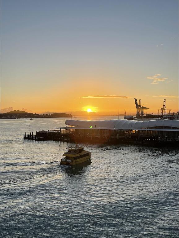 a boat in the water with the sunset in the background at Princes Wharf - Luxury in Auckland