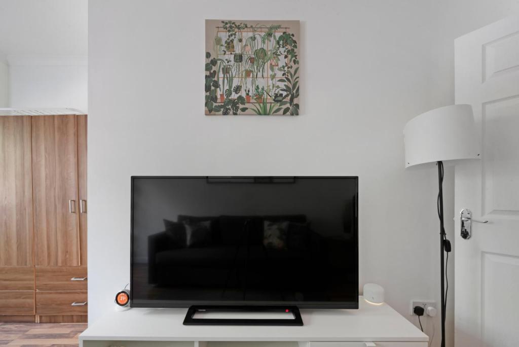 a living room with a large flat screen tv on a wall at Old Street Apartments By Morethanstays in London