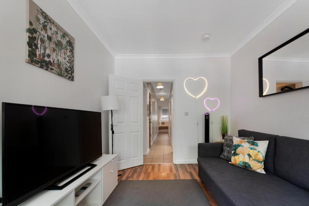 a living room with a couch and a flat screen tv at Old Street Apartments By Morethanstays in London