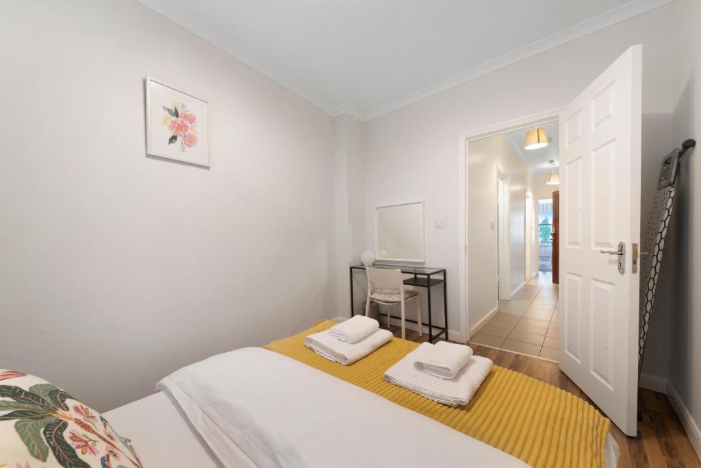 a bedroom with a bed with two towels on it at Old Street Apartments By Morethanstays in London
