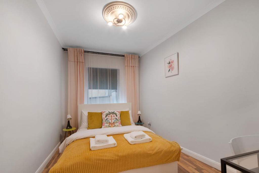 a bedroom with a bed with two towels on it at Old Street Apartments By Morethanstays in London