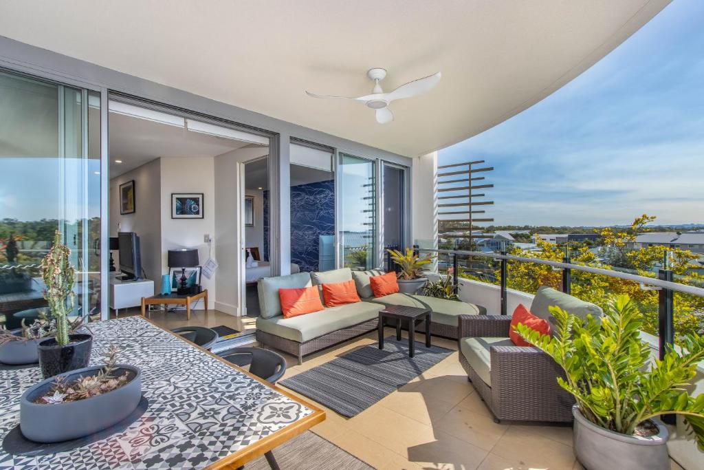 un salon avec un canapé et une table dans l'établissement Casuarina Resort Style 3BR Apartment by uHoliday, à Casuarina