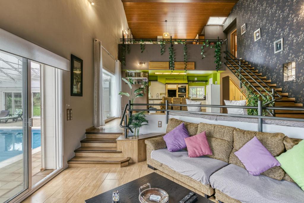 sala de estar con sofá y piscina en Casa Nadia, en Romanyà de la Selva