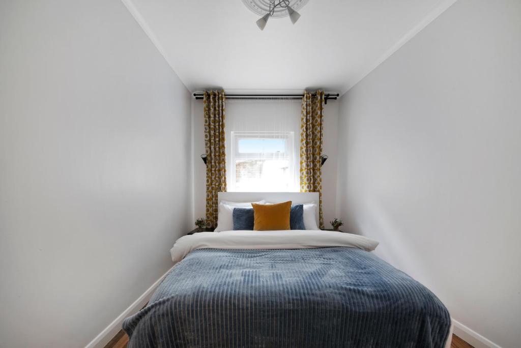 a small bedroom with a bed with a window at Old Street Apartments By Morethanstays in London