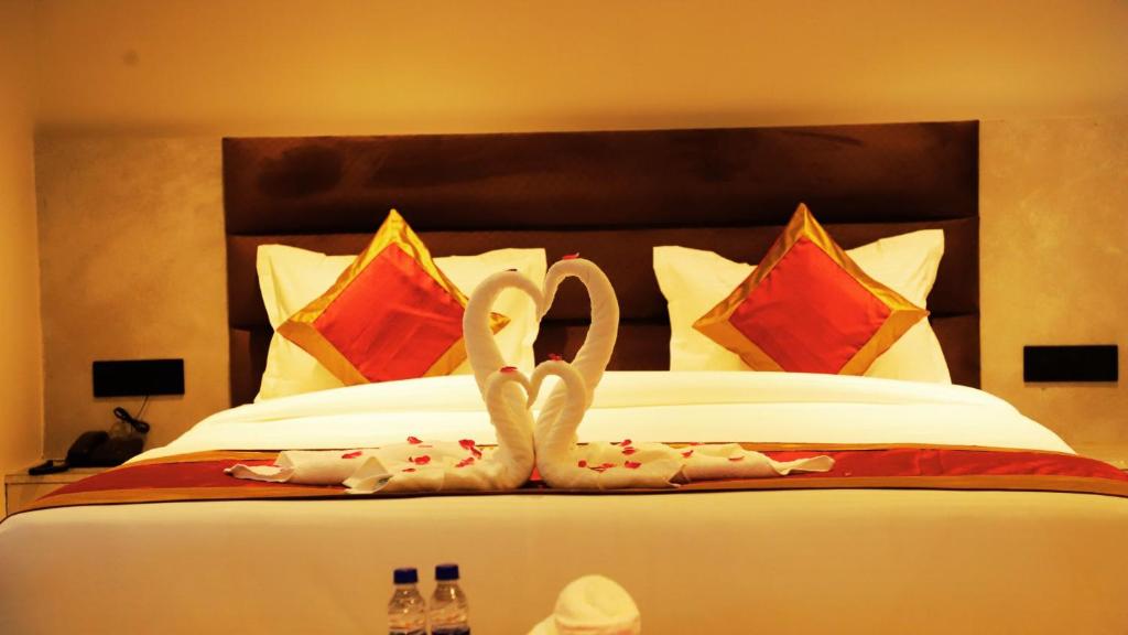 una cama con dos cisnes hechos de toallas en Hotel Kamakhya Inn By BookingCare, en Chhatarpur