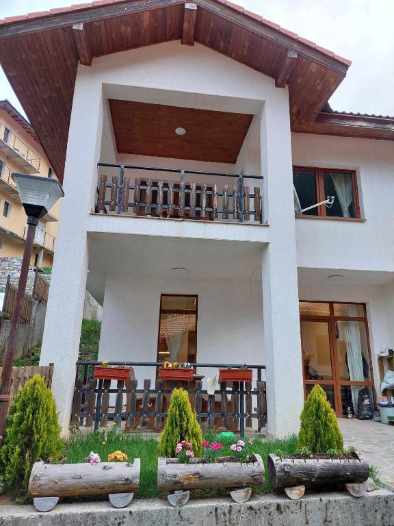 a house with a balcony with tables and chairs at Villa Victoria in Stoykite