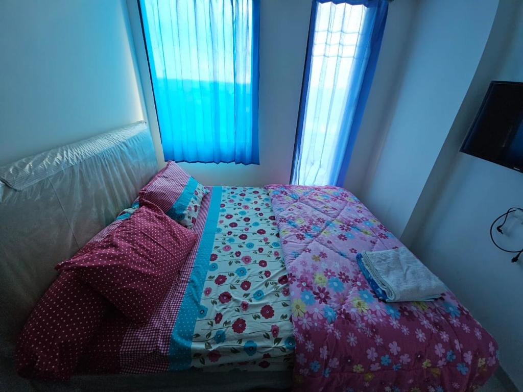 OSAKA RIVERVIEW في تانغيرانغ: غرفة نوم مع سرير مع لحاف ووسائد