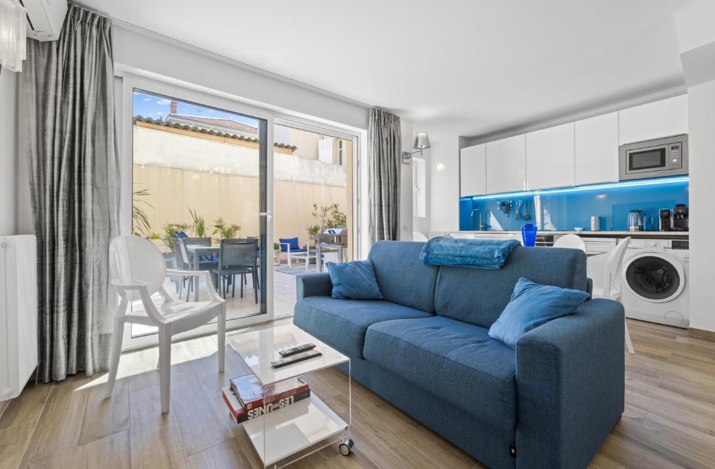 a living room with a blue couch and a dining room at Cannes NG - Appartement à 10 mn du Palais des Festivals in Cannes