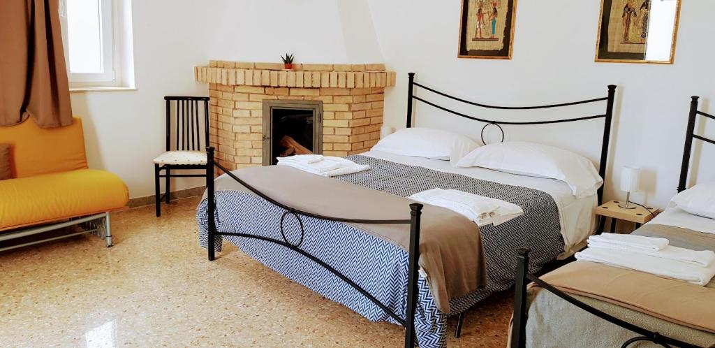 a bedroom with two beds and a fireplace at Masseria Santa Maria in Gravina in Puglia