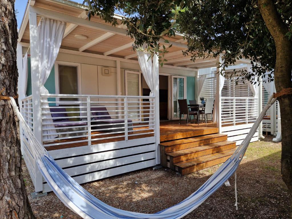 a hammock on the front porch of a house at OTIUM mobile homes in Biograd na Moru
